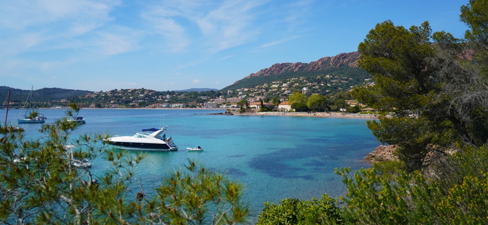 Location de bateau dans la baie d'Agay avec les roches rouges de l'Estérel en arrière-plan