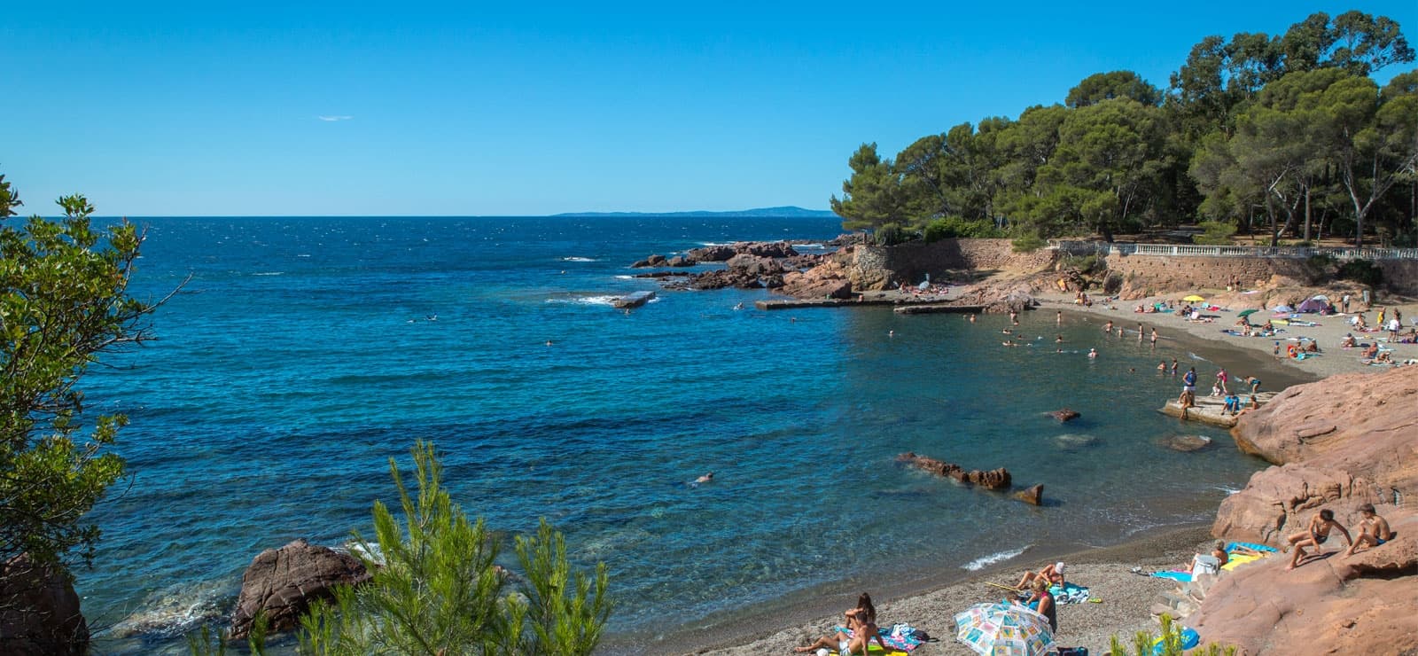 Location de bateau arrivant au Port du Toukan à Boulouris avec les pins et l'Estérel en arrière-plan